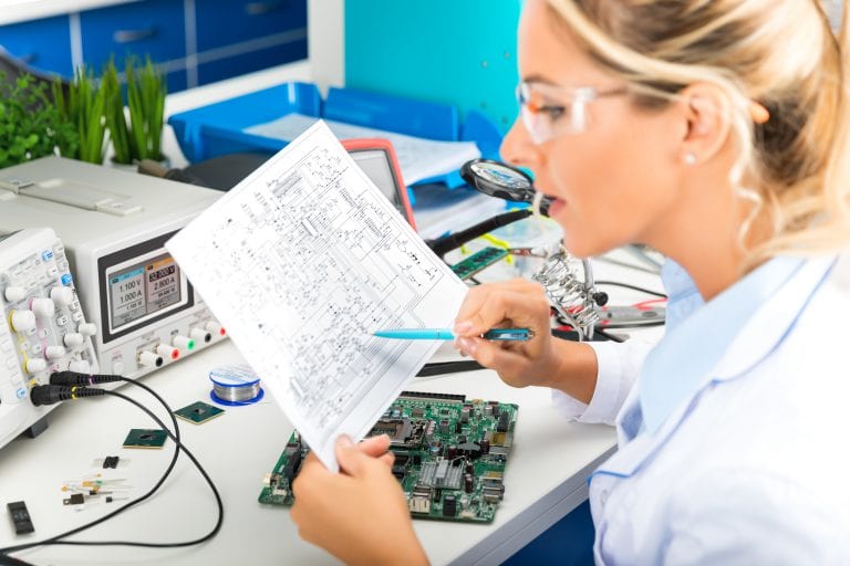 Young attractive female digital electronic engineer checking electronic circuit in laboratory