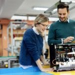 Young attractive students of mechatronics working on project together