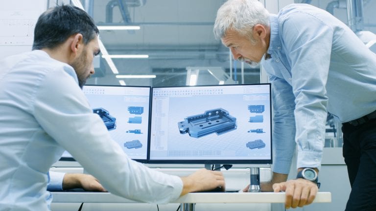 Industrial Designer Has Conversation with Senior Engineer While Working in CAD Program, Designing New Component. He Works on Personal Computer with Two Monitors.