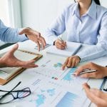 Close-up image of business team talking about charts and graphs at the meeting