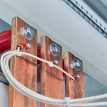 Electrical wires are connected to copper busbars. Busbars are fixed to the circuit Board through red insulators. Electrical equipment is installed in the enclosure of the electrical Cabinet.