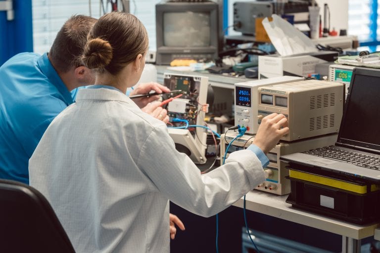 Team of electronic engineers testing a product prototype on test bench in the lab