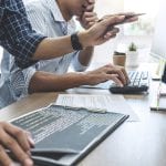 Two professional programmers cooperating at Developing programming and website working in a software develop company office, writing codes and typing data code.