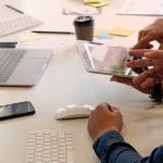 Website designer planning and meeting application development layout framework and coding program on paper and computer.