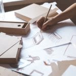 Designer draws a mockup for crafting cardboard box. Development of packaging design sketch.