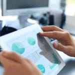 Business person analyzing financial statistics displayed on the tablet screen